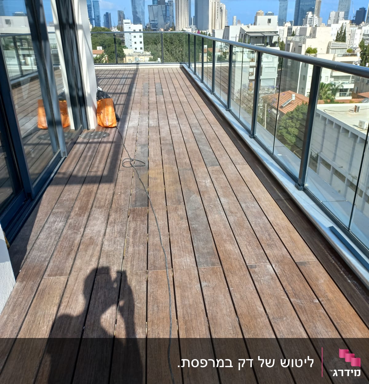 מרפסת עץ עם שקי עבודה וצל אדם